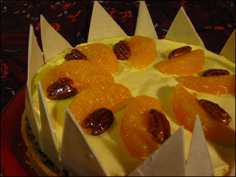 A rich and crisp pastry shell filled with pecan nuts in a caramel base gently infused with cinnamon, topped with an impossibly light orange mousse, orange segments and caramelised pecans, surrounded by white chocolate shards.